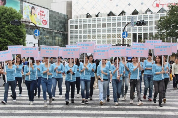 “AKB48 渋谷で一日『心のプラカード』祭り！”で街中を歩く20名の女性。