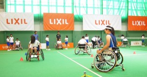 車いすテニスの体験をする小学生と見守る船水梓緒里選手