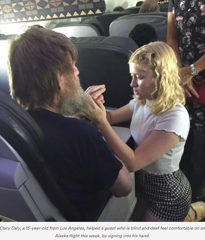 ティムさんの手にアルファベットを記すクララさん（画像は『Alaska Airlines Blog　2018年6月22日付「Heartwarming inflight experience proves everything happens for a reason」』のスクリーンショット）