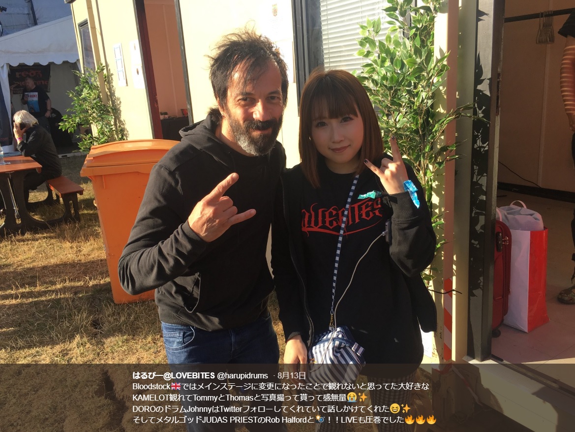 ドロ・ペッシュのバンドのドラマー、ジョニー・ディーとharuna（画像は『はるぴー＠LOVEBITES　2018年8月13日付Twitter「Bloodstock ではメインステージに変更になったことで観れないと思ってた大好きなKAMELOT観れてTommyとThomasと写真撮って貰って感無量」』のスクリーンショット）