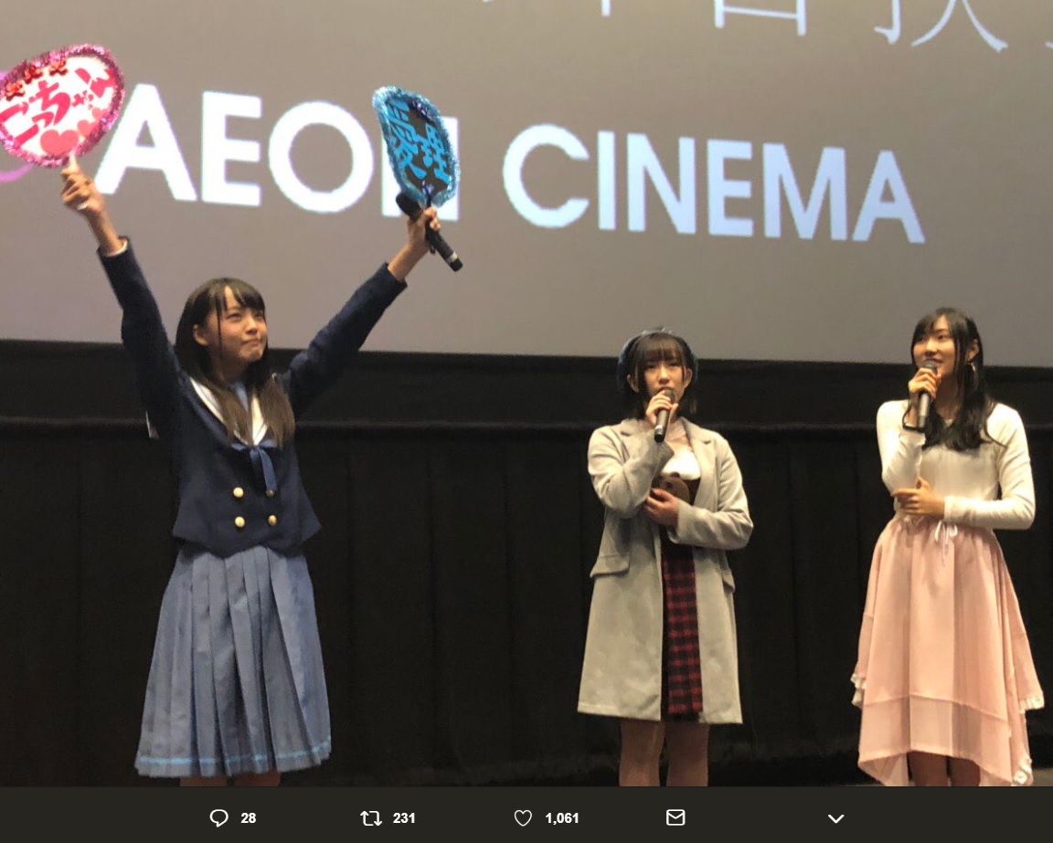 舞台挨拶で推しうちわを掲げるSTU48福田朱里とマイクを持つSKE48水野愛理・白井琴望（画像は『竹中優介　2018年11月11日付Twitter「イオンシネマ岡山での ＃映画アイドル 舞台挨拶始まりました！」』のスクリーンショット）