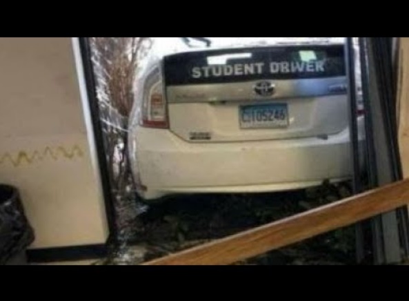教習車がバックに失敗。飛び込んだ先は…（画像は『ArchProductionHD　2018年4月4日公開 YouTube「Video shows student driver crash through DMV window while taking test」』のサムネイル）