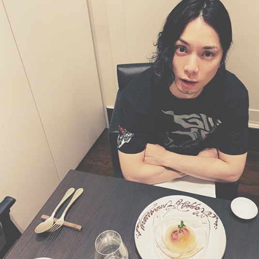 結婚記念日のプレートを前にした水嶋ヒロ（画像は『Hiro Mizushima　2020年2月24日付Instagram「結婚12年目」』のスクリーンショット）