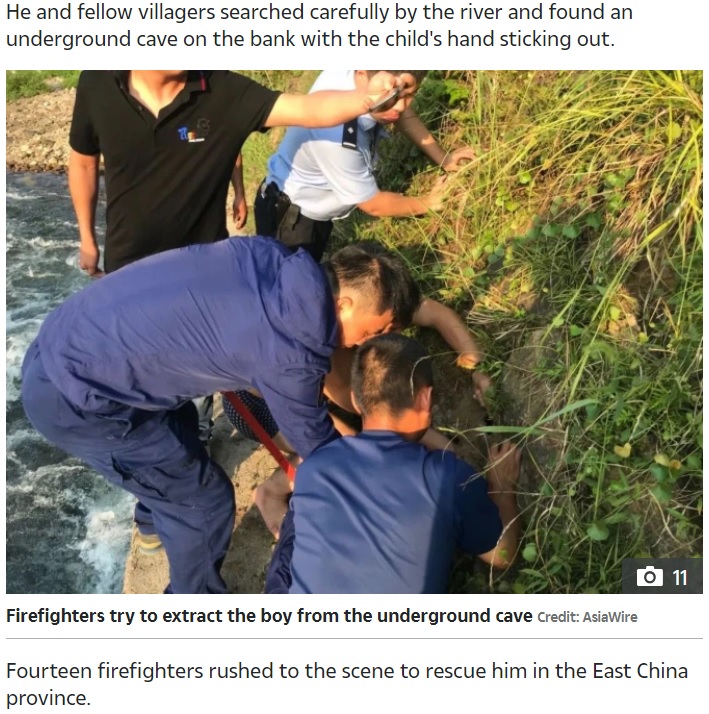 男児を救出する消防士たち（画像は『The Sun　2020年7月27日付「‘HE’S ALIVE!’ Dramatic moment trapped boy, 7, reaches for grandpa through crack in ground after river swept him into underground cave」（Credit: AsiaWire）』のスクリーンショット）