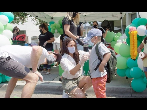 バックパックを選ぶ手伝いをするメーガン妃（画像は『Baby2Baby　2020年8月21日付Instagram「Baby2Baby was proud to host a drive-through distribution at Knox Elementary in South LA as students across the country return to distance learning this week.」』のスクリーンショット）