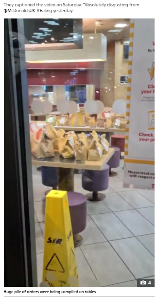 テーブルには大量の注文された商品が（画像は『The Sun　2021年1月12日付「NOT HAPPY MEAL McDonald’s worker ‘close to tears’ as she’s forced to handle stack of delivery orders alone in ‘disgusting’ scenes」』のスクリーンショット）