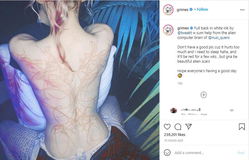 背中のタトゥーを「エイリアンの傷痕」と表現したグライムス（画像は『grimes　2021年4月11日付Instagram「Full back in white ink by ＠tweakt w sum help from the alien computer brain of ＠nusi_quero」』のスクリーンショット）