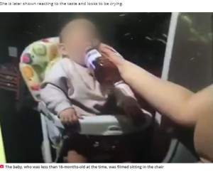 ワインボトルから直接飲まされる女児（画像は『Daily Record　2021年8月24日付「Moment Scots baby ‘fed wine’ in clip that shocked and distressed social media users」（Image: UGC）』のスクリーンショット）