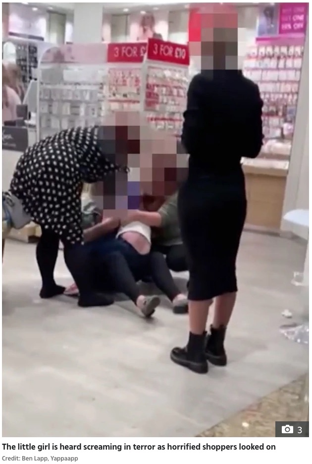 激しく泣き叫ぶ女児（画像は『The Sun　2021年10月20日付「‘GET OFF!’ Distressing moment young girl ‘screams in terror’ as she’s ‘pinned down to have ears pierced’ in shop」（Credit: Ben Lapp, Yappaapp）』のスクリーンショット）