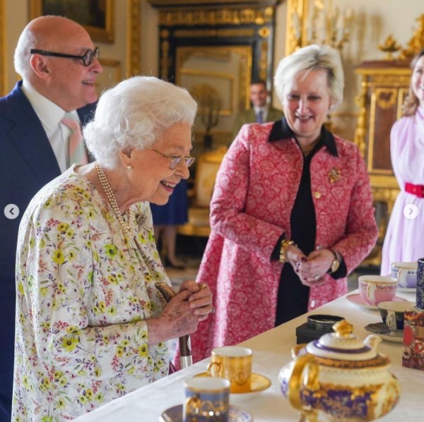 「ハルシオン・デイズ」の作品を鑑賞する女王（画像は『The Royal Family　2022年3月25日付Instagram「This week at Windsor Castle, The Queen viewed a selection of enamel and fine bone china artefacts from ＠HalcyonDays_UK, to commemorate their 70th anniversary.」』のスクリーンショット）