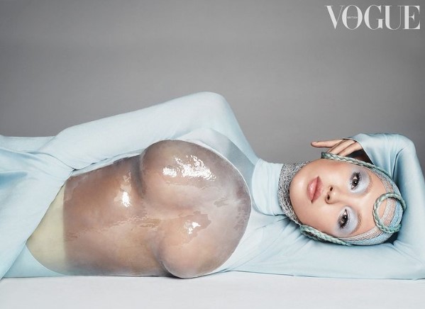 近未来的なメイクを施し、胸当て付きの衣装を着るライラ（画像は『British Vogue　2022年4月21日付Instagram「Landing her debut ＃BritishVogue cover is a major milestone for ＠LilaMoss.」』のスクリーンショット）