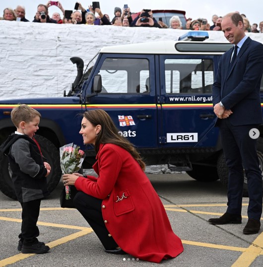 テオ君から花束を受け取るキャサリン皇太子妃（画像は『The Prince and Princess of Wales　2022年9月27日付Instagram「Diolch Anglesey!」』のスクリーンショット）