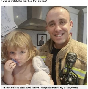 ハーパーちゃんと助けてくれた消防隊員（画像は『Metro　2022年11月3日付「Girl, 2, saved by firefighters after getting toilet seat stuck on her head」（Picture: Kay Stewart/SWNS）』のスクリーンショット）