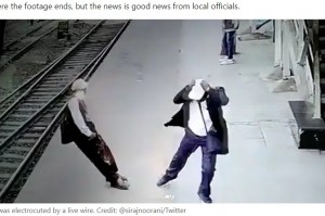 直立したまま後方に倒れるスジャンさん（画像は『LADbible　2022年12月8日付「Railway worker cheats death after falling onto train tracks and getting electrocuted in shocking video」（Credit: ＠sirajnoorani/Twitter）』のスクリーンショット）