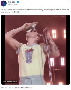 自分のスニーカーで一気飲みをするハリー（画像は『Pop Base　2023年2月20日付Twitter「Harry Styles does Australian tradition Shoey,」』のスクリーンショット）