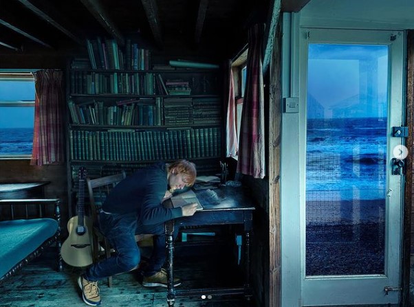 海が見える部屋でファンに向けたメッセージを書くエド（画像は『Ed Sheeran　2023年3月1日付Instagram「I had been working on Subtract for a decade,」』のスクリーンショット）