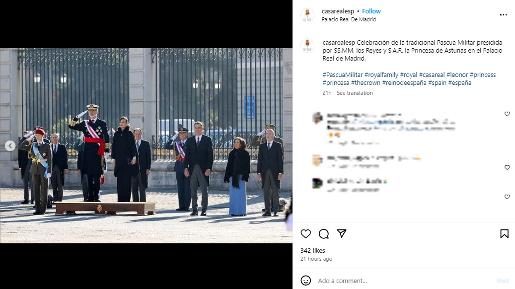 宮殿前で敬礼をする国王と皇太子。国王の後部では、黒いコートを着たレティシア王妃が立っている（画像は『Casa de S.M. el Rey　2024年1月6日付Instagram「Celebración de la tradicional Pascua Militar presidida por SS.MM. los Reyes y S.A.R. la Princesa de Asturias en el Palacio Real de Madrid.」』のスクリーンショット）