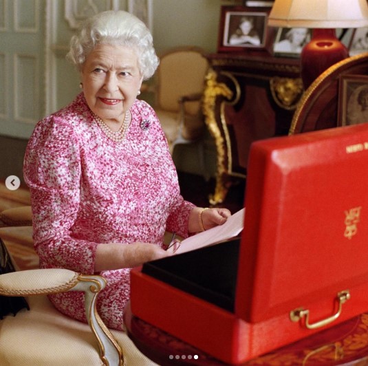 2015年、バッキンガム宮殿で赤い箱に入った書類を確認するエリザベス女王。即位して以来、毎日この箱は女王のもとに届けられた（画像は『The Royal Family　2022年2月6日付Instagram「This photograph has been released to mark Accession Day 2022:」』のスクリーンショット）
